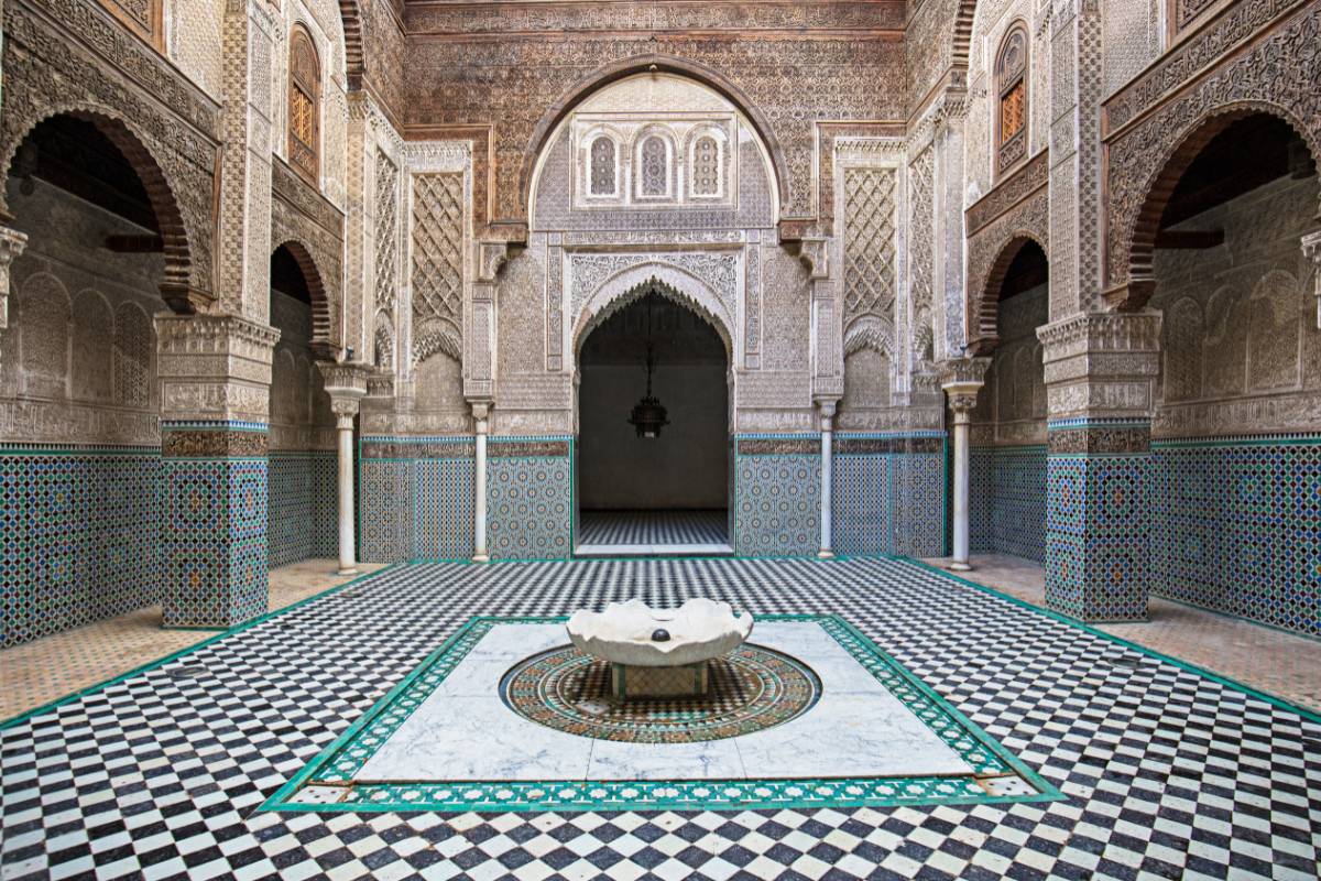 Ornate Moroccan architectural interior with traditional zellige geometric tilework and carved arches