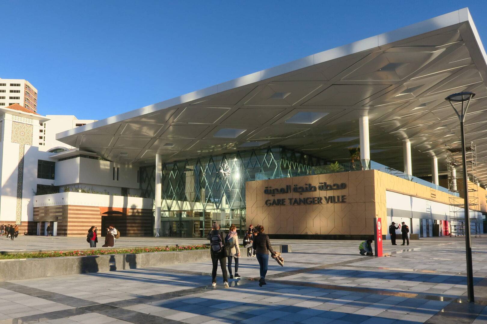 Modern train station with people outside.